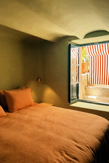 Porta de persiana amb marc de fusta en una habitació de l'Hotel Corazón