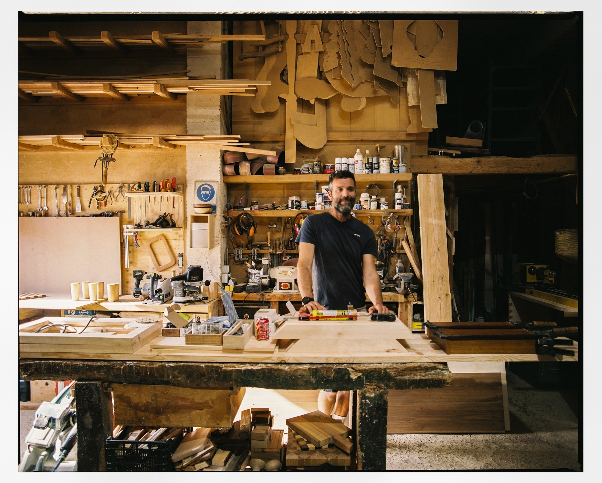 A woodworker's hands shaping a piece at the bench.